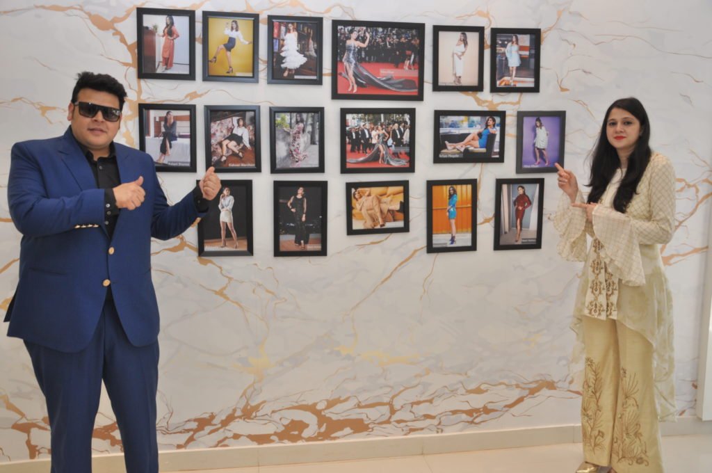 Sudeep Bamra & Heena Singh pose alongside a wall showcasing photos of celebs wearing Dech Barroucis' at the unveiling of their outlet 'Dech Barrouci' - an affordable luxury women footwear label